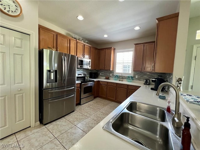 kitchen with sink, backsplash, light tile patterned floors, and appliances with stainless steel finishes