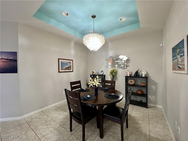 tiled dining room featuring a tray ceiling