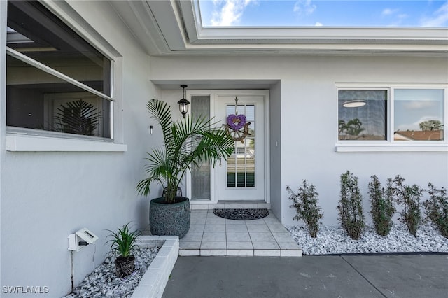 entrance to property featuring stucco siding