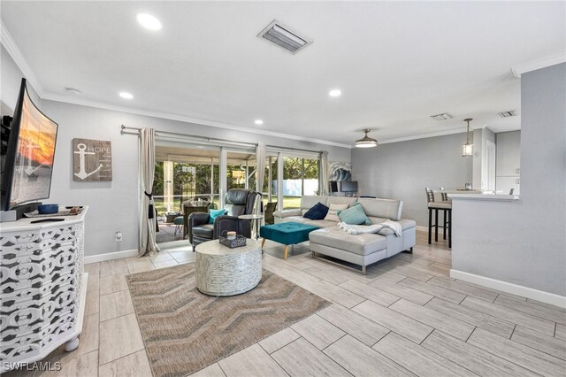 living area featuring visible vents, crown molding, and baseboards