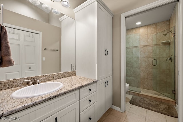 full bathroom featuring a stall shower, vanity, toilet, and tile patterned floors