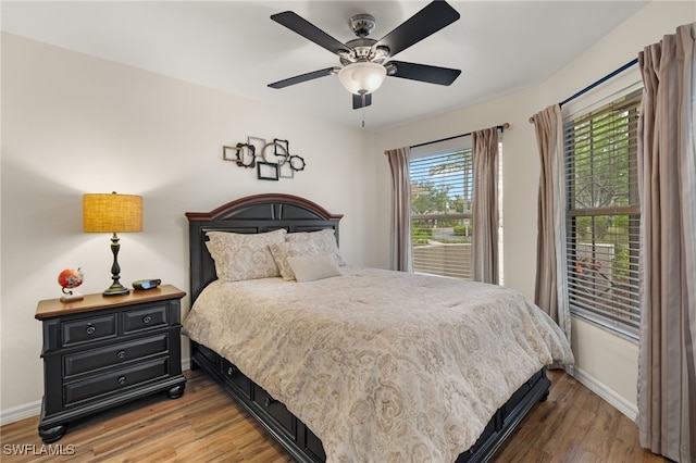 bedroom with light wood-style floors, baseboards, and a ceiling fan