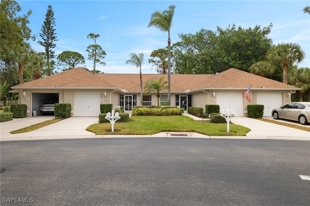 ranch-style house featuring a garage and a front lawn