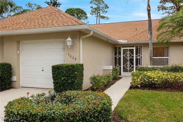 property entrance with a shingled roof, a garage, and stucco siding