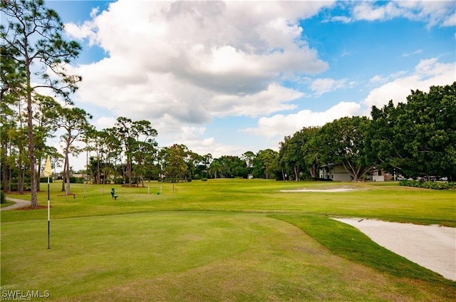 view of home's community featuring view of golf course and a yard