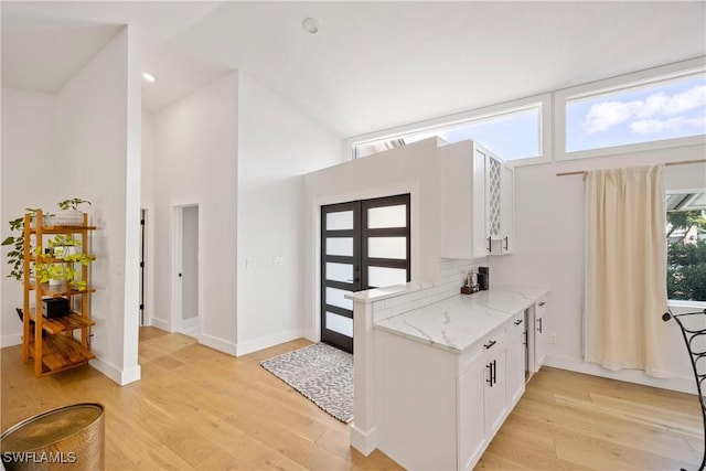 kitchen featuring a high ceiling and light wood-type flooring