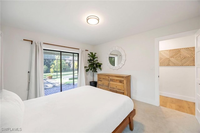 bedroom featuring access to exterior and light hardwood / wood-style flooring