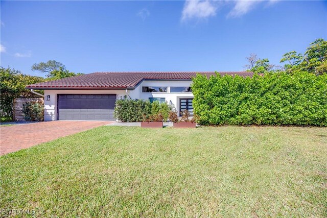 view of front of house with a garage and a front lawn