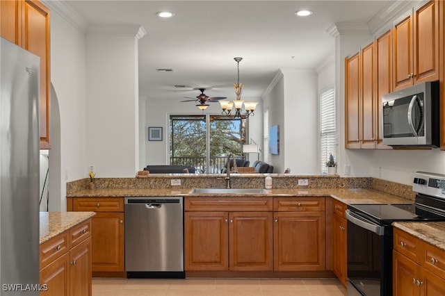 kitchen with sink, crown molding, hanging light fixtures, stainless steel appliances, and light stone counters