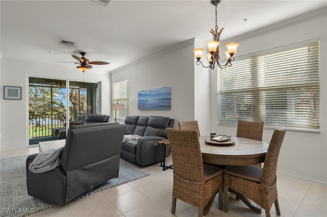 tiled dining space with ornamental molding and ceiling fan with notable chandelier