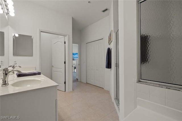 bathroom featuring vanity, a shower with shower door, and tile patterned flooring