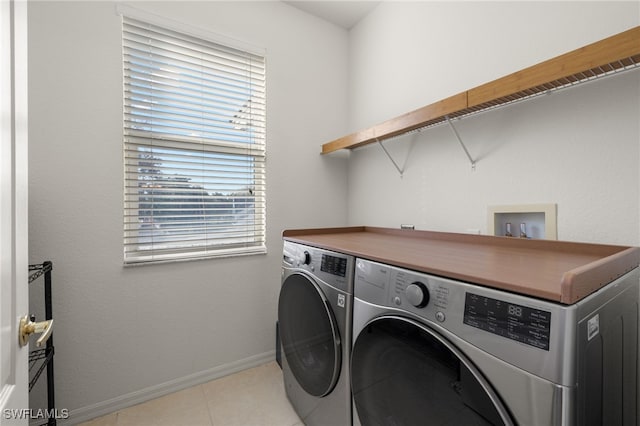 clothes washing area with light tile patterned floors and washing machine and dryer