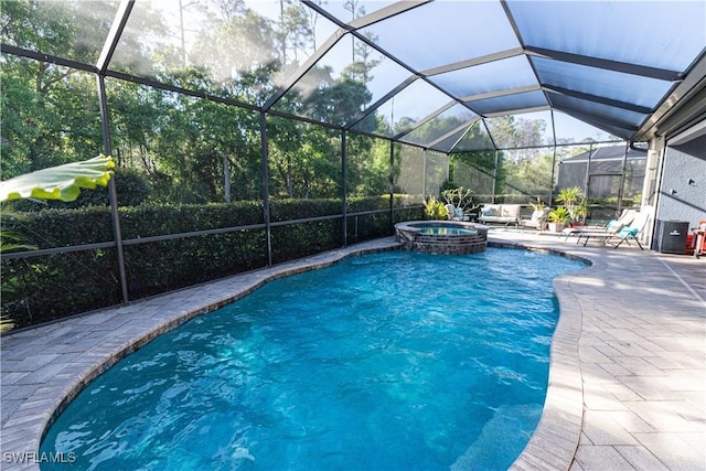 view of swimming pool featuring an in ground hot tub, a lanai, and a patio