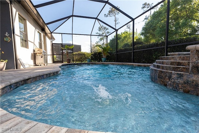 view of pool with pool water feature, a patio area, and glass enclosure