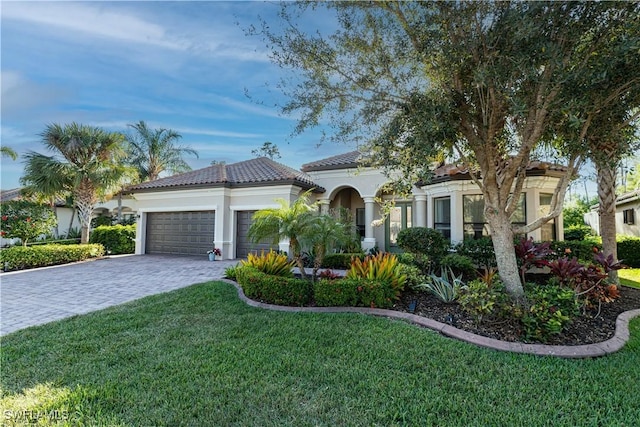 mediterranean / spanish house with a garage and a front yard