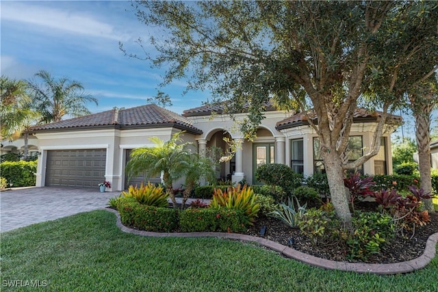 mediterranean / spanish-style home with a garage and a front lawn