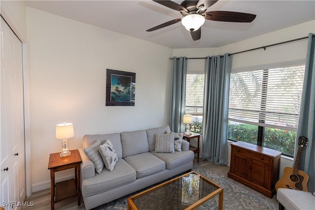 living room with ceiling fan and light hardwood / wood-style flooring