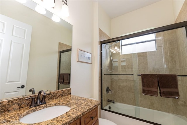 full bathroom featuring vanity, toilet, and combined bath / shower with glass door