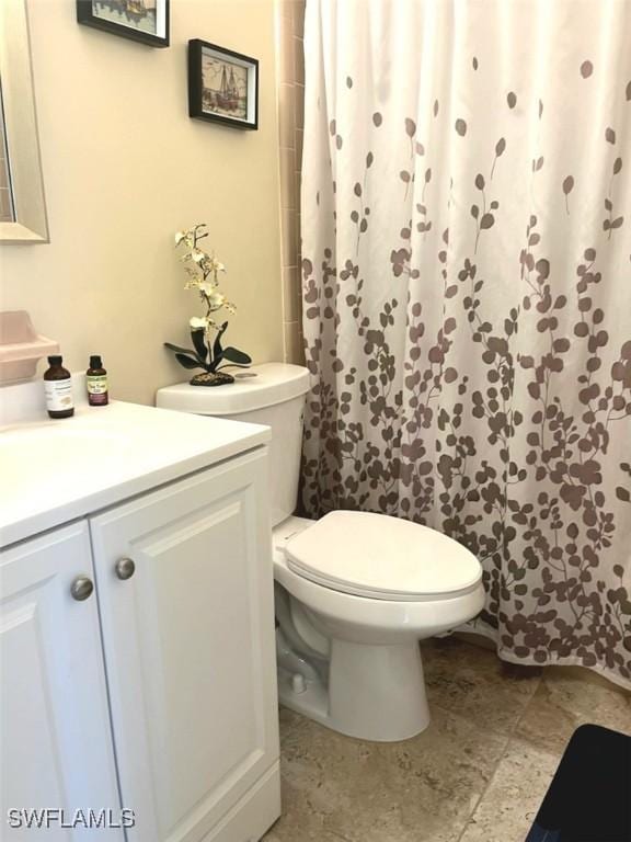 bathroom with a shower with curtain, vanity, and toilet