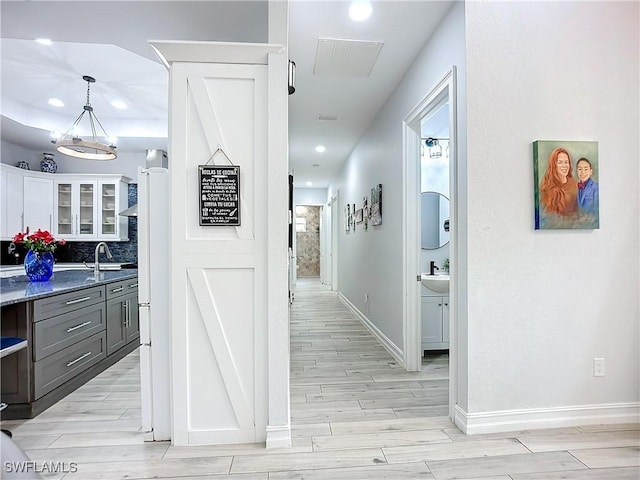 7684 County Rd 78, Fort Denaud, FL 33935 - corridor with baseboards, wood tiled floor, visible vents, and a sink
