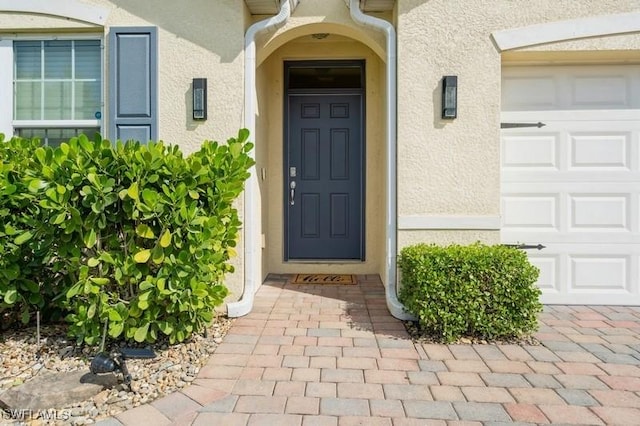 view of exterior entry with a garage