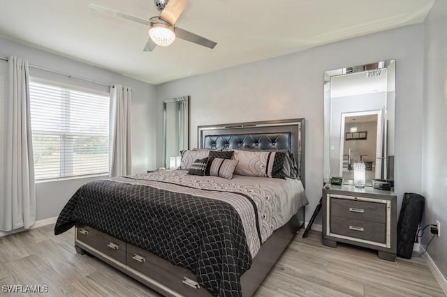 bedroom with light hardwood / wood-style floors and ceiling fan