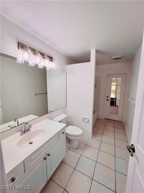 bathroom featuring vanity, tile patterned floors, and toilet