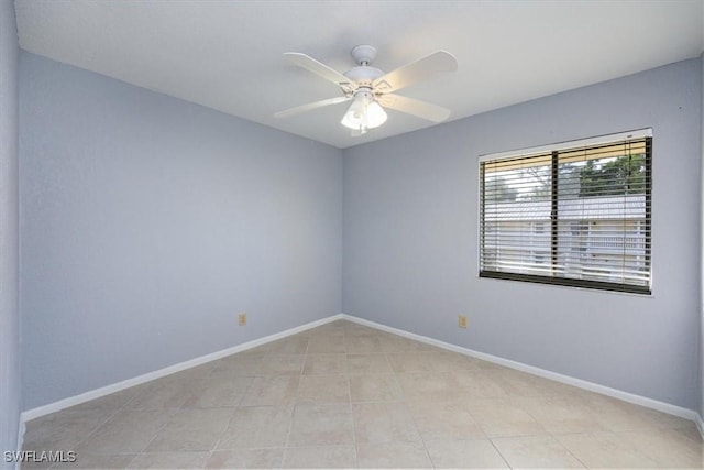 spare room with ceiling fan and light tile patterned floors