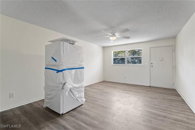 spare room featuring ceiling fan, wood-type flooring, and a textured ceiling