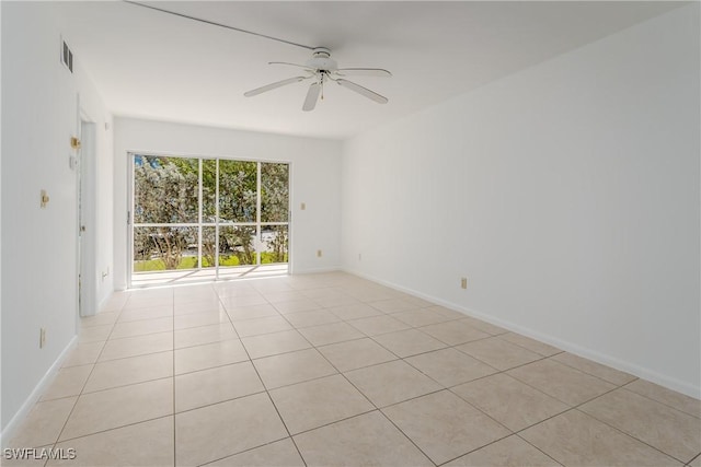 empty room with ceiling fan and light tile patterned floors