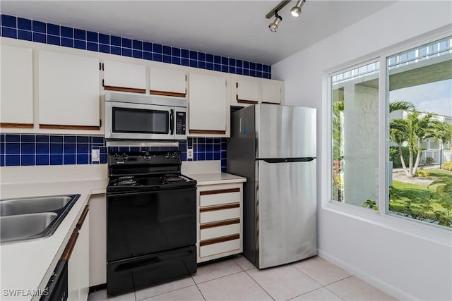 kitchen featuring stainless steel appliances, sink, a wealth of natural light, and white cabinets