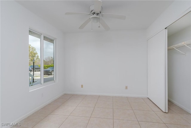 unfurnished bedroom featuring light tile patterned flooring, ceiling fan, and a closet