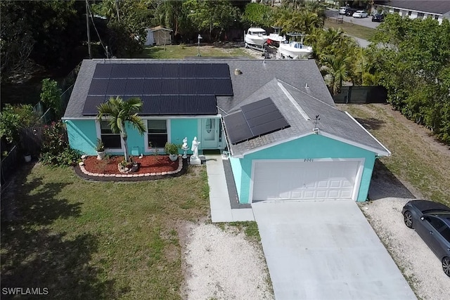 view of front facade featuring a garage, a front yard, and solar panels