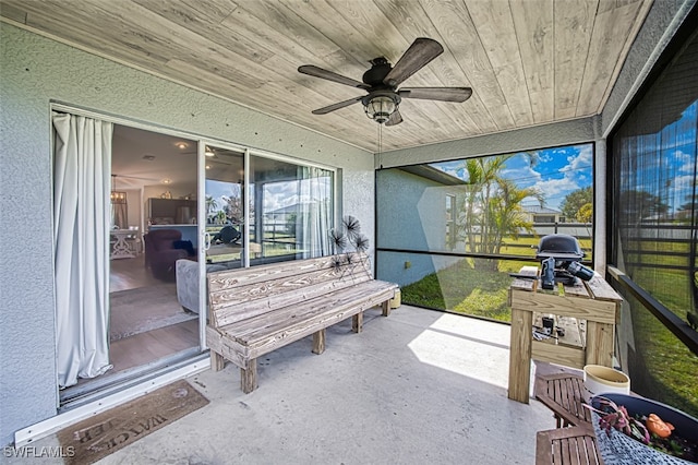 sunroom / solarium with wood ceiling and ceiling fan