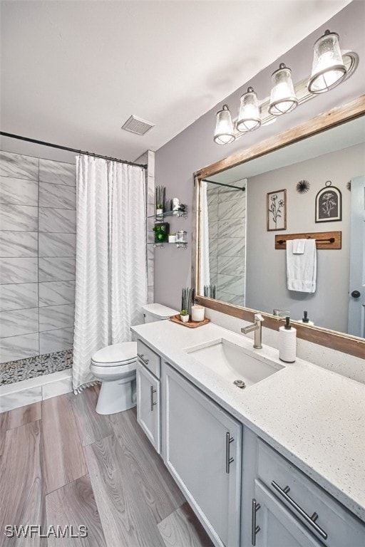 bathroom with vanity, toilet, a shower with shower curtain, and wood-type flooring