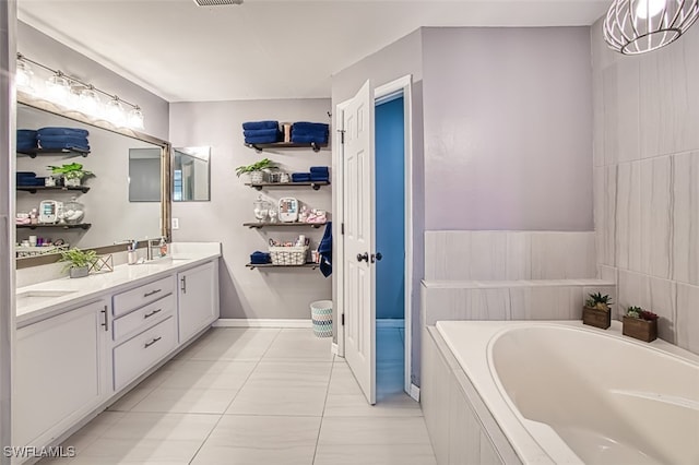 bathroom featuring vanity, tiled bath, and tile patterned flooring