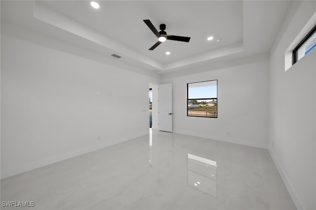 2125 Trafalgar Pkwy, Cape Coral, FL 33991 - empty room with a tray ceiling, healthy amount of natural light, a ceiling fan, recessed lighting, and baseboards