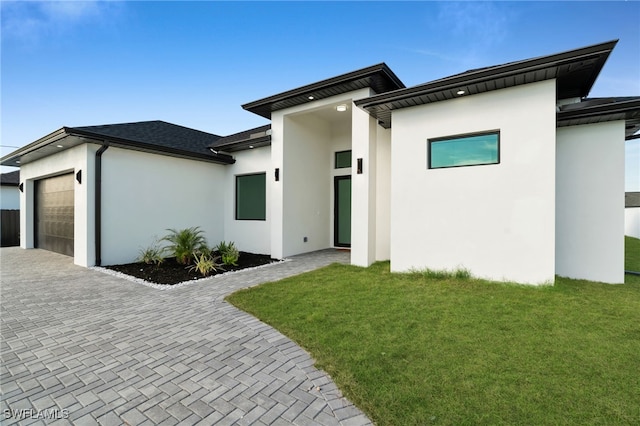 2125 Trafalgar Pkwy, Cape Coral, FL 33991 - contemporary home with stucco siding, a garage, decorative driveway, and a front yard