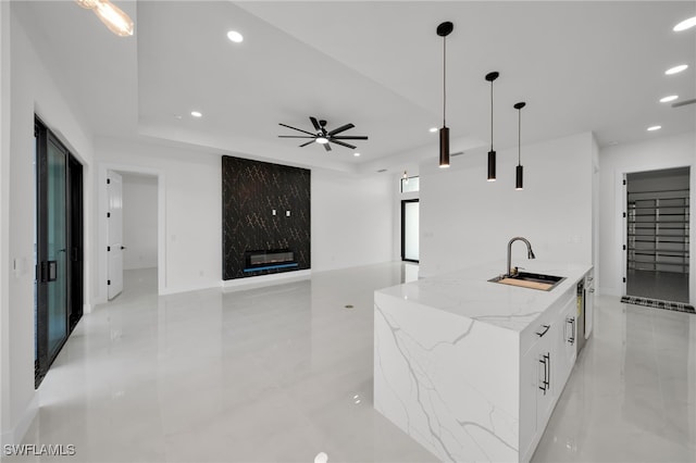 2125 Trafalgar Pkwy, Cape Coral, FL 33991 - kitchen with a sink, modern cabinets, recessed lighting, an island with sink, and a premium fireplace