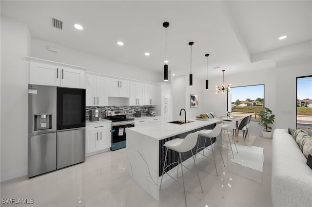 2125 Trafalgar Pkwy, Cape Coral, FL 33991 - kitchen with appliances with stainless steel finishes, white cabinetry, a center island with sink, and recessed lighting