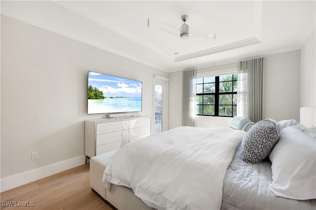 bedroom featuring a tray ceiling, ornamental molding, and light hardwood / wood-style floors