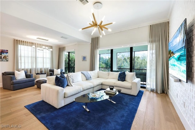 living room featuring ornamental molding, wood-type flooring, and a notable chandelier