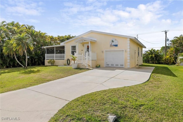 view of front of home with a garage, a sunroom, and a front lawn