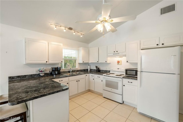 kitchen featuring white appliances, visible vents, a peninsula, a sink, and under cabinet range hood