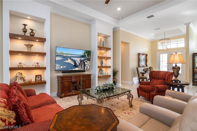 living room with ornamental molding, ceiling fan with notable chandelier, built in features, and a tray ceiling