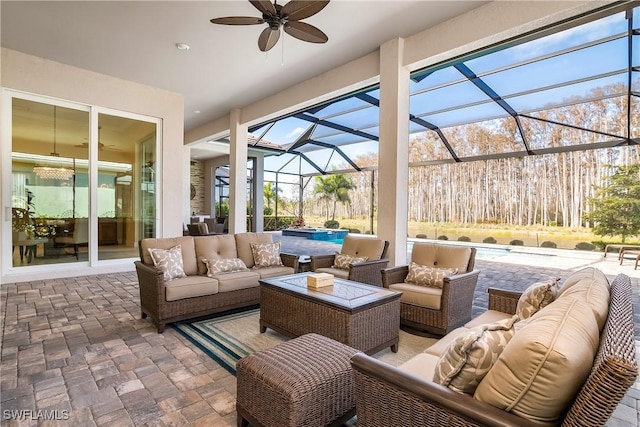 view of patio featuring ceiling fan, an outdoor hangout area, and glass enclosure