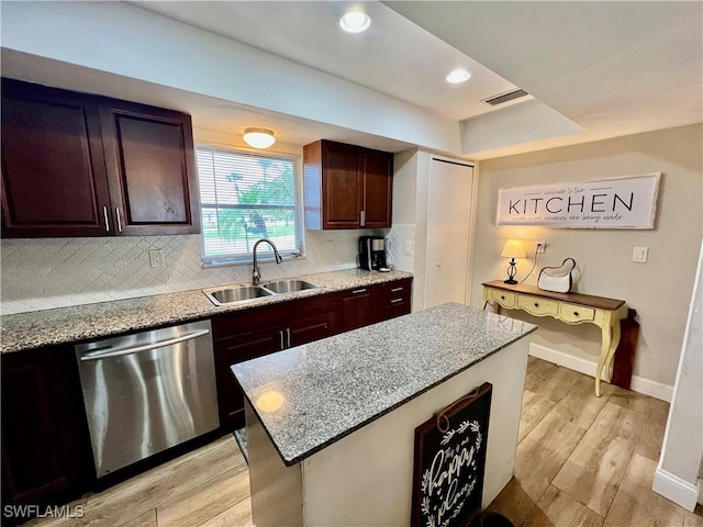 kitchen with sink, a center island, light wood-type flooring, stainless steel dishwasher, and backsplash