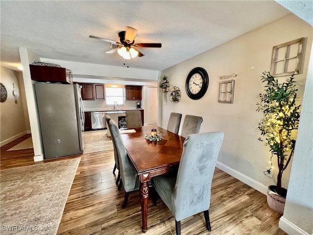 dining space featuring ceiling fan, light hardwood / wood-style flooring, and a textured ceiling