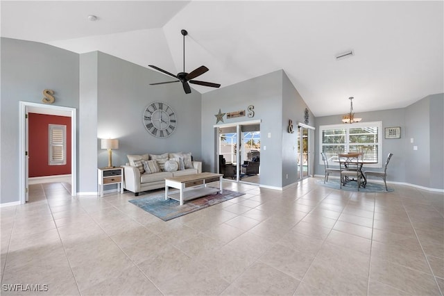 tiled living room featuring ceiling fan with notable chandelier and high vaulted ceiling