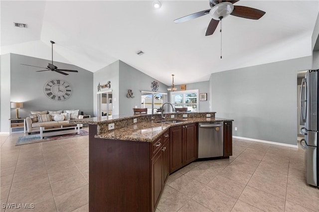 kitchen featuring lofted ceiling, sink, light tile patterned floors, dark stone countertops, and stainless steel appliances